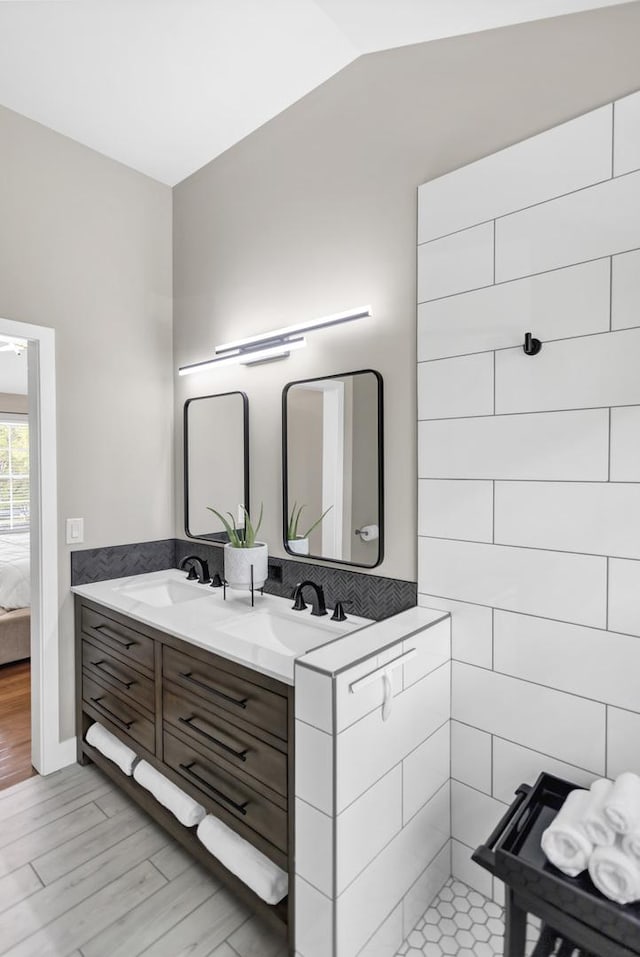 3174 Larrabee Dr, Geneva, IL 60134 - full bathroom with double vanity, wood finished floors, connected bathroom, and vaulted ceiling