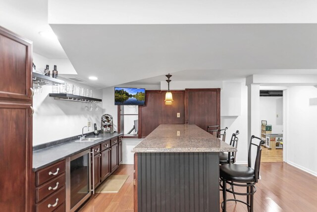 3174 Larrabee Dr, Geneva, IL 60134 - kitchen featuring wine cooler, open shelves, light wood-type flooring, a breakfast bar, and a center island