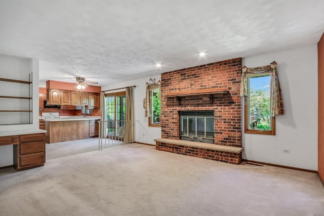 10762 W Talmadge Ave, Beach Park, IL 60099 - unfurnished living room featuring healthy amount of natural light, a brick fireplace, light colored carpet, and baseboards