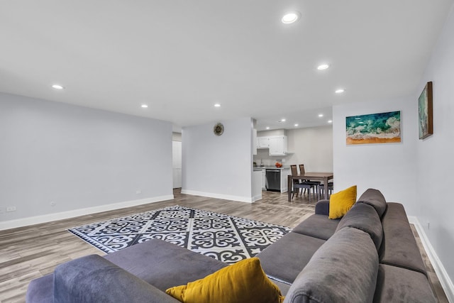 living area featuring wood finished floors, baseboards, and recessed lighting