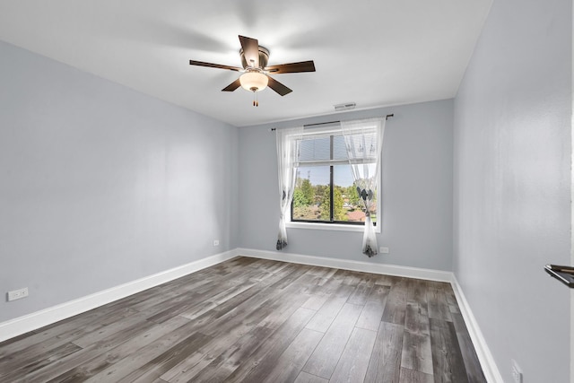 empty room with ceiling fan, wood finished floors, and baseboards