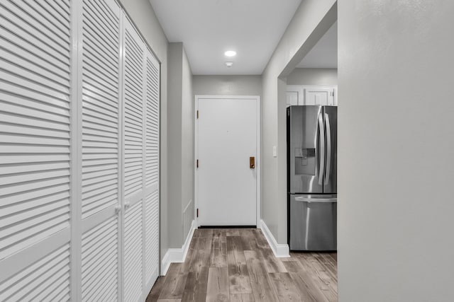 corridor featuring wood finished floors, baseboards, and recessed lighting