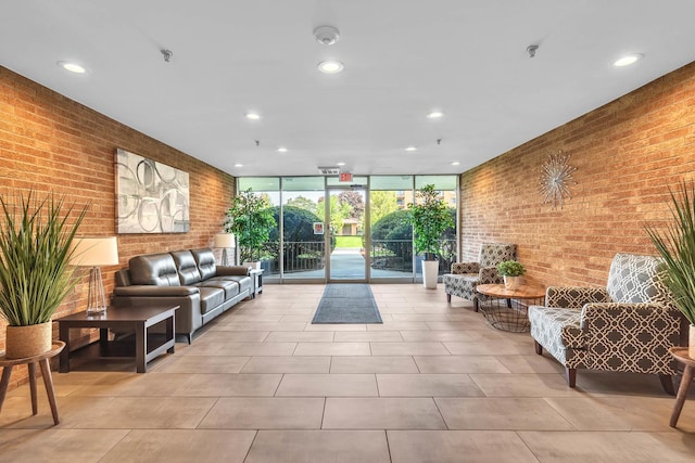 building lobby with brick wall, floor to ceiling windows, and recessed lighting