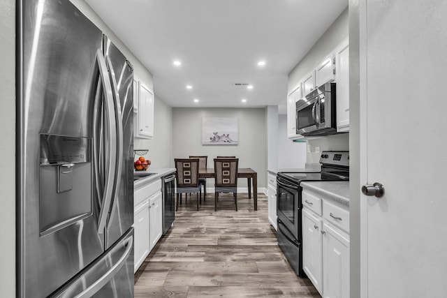 kitchen with stainless steel appliances, light countertops, recessed lighting, white cabinets, and wood finished floors