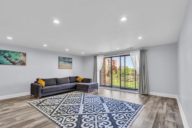 living room with wood finished floors, baseboards, and recessed lighting