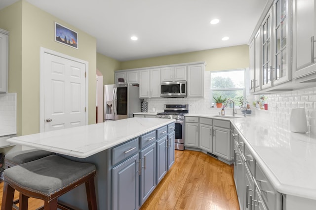 1984 Seaview Dr, Aurora, IL 60503 - kitchen featuring stainless steel appliances, a sink, a center island, a kitchen breakfast bar, and light wood finished floors