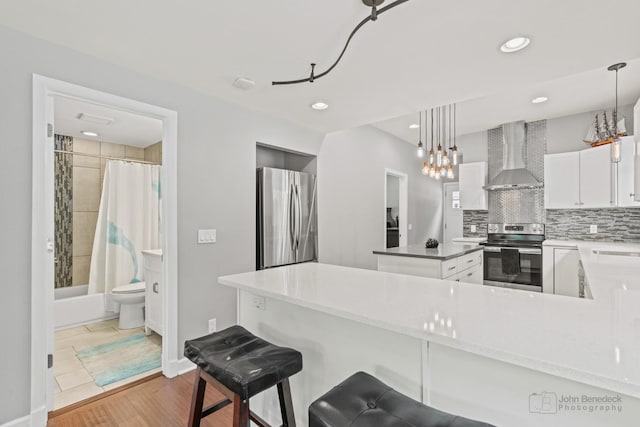 28271 W Stewart Ave, Spring Grove, IL 60081 - kitchen with stainless steel appliances, wall chimney range hood, pendant lighting, a kitchen island, and decorative backsplash
