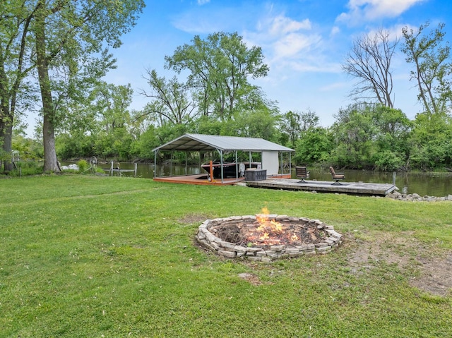 28271 W Stewart Ave, Spring Grove, IL 60081 - view of grassy yard with a fire pit, a boat dock, a carport, a water view, and view of scattered trees