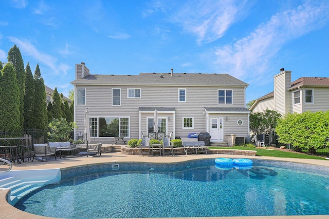 view of swimming pool with outdoor lounge area, a patio, and fence