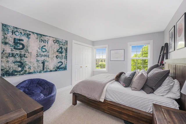 carpeted bedroom featuring baseboards and a closet