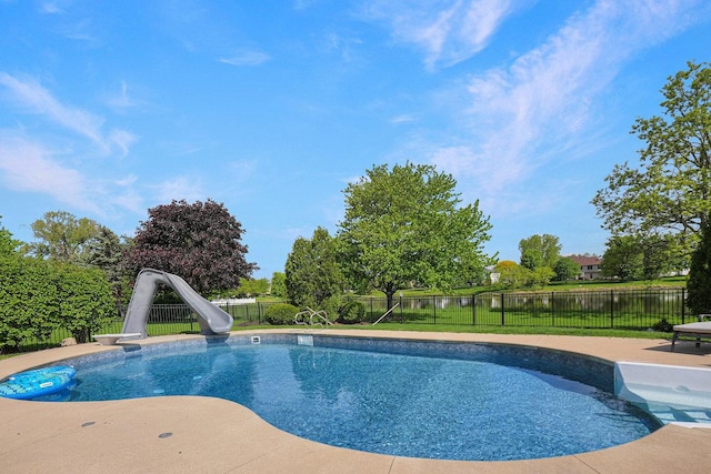 view of pool with a water slide, a fenced backyard, a patio, and a water view