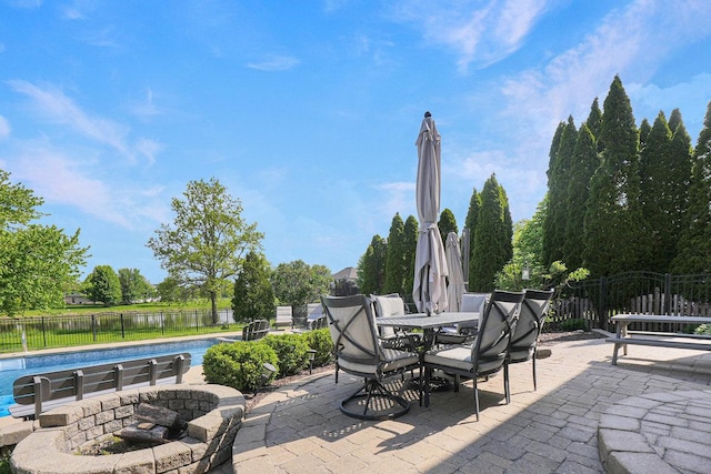 view of patio featuring fence, outdoor dining space, and a water view