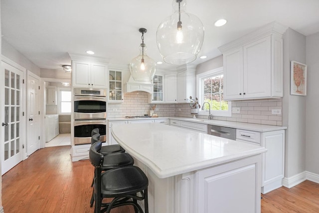 kitchen featuring stainless steel appliances, light countertops, white cabinets, decorative backsplash, and recessed lighting