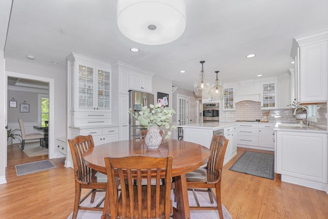 dining room with light wood-style flooring and recessed lighting