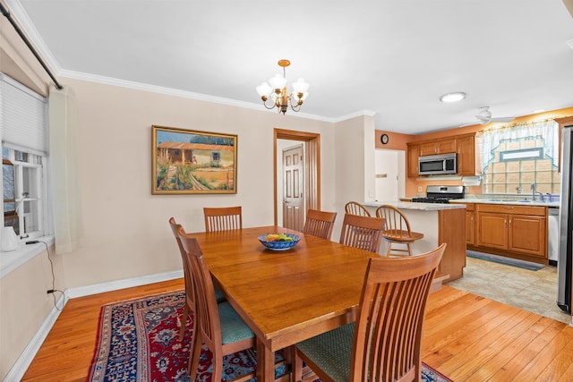 6914 S Cregier Ave, Chicago, IL 60649 - dining room featuring light wood finished floors, a chandelier, crown molding, and baseboards