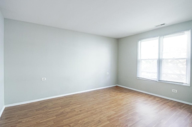 spare room with light wood-style flooring and baseboards