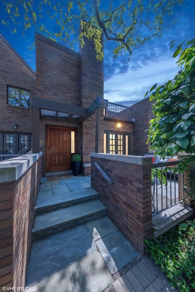 509 Burr Oak Pl, Hinsdale, IL 60521 - exterior entry at dusk featuring brick siding and a chimney