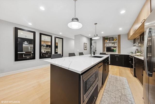 509 Burr Oak Pl, Hinsdale, IL 60521 - kitchen featuring a sink, appliances with stainless steel finishes, light wood-type flooring, a center island with sink, and decorative light fixtures