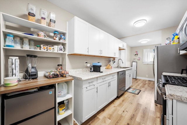 224 S 8th St, Dekalb, IL 60115 - kitchen featuring stainless steel appliances, light wood-type flooring, open shelves, and white cabinets