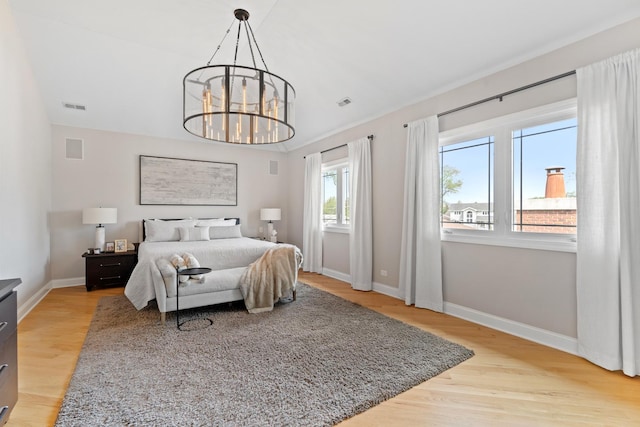 8260 W Argyle St, Norridge, IL 60706 - bedroom with light wood-style flooring, baseboards, and a chandelier