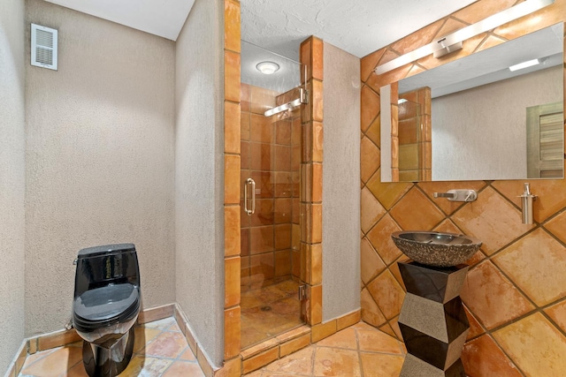 8260 W Argyle St, Norridge, IL 60706 - full bathroom with toilet, a shower stall, a sink, tile patterned floors, and a textured wall