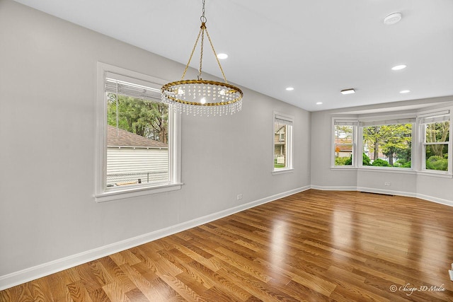 5935 Carol Ave, Morton Grove, IL 60053 - empty room featuring healthy amount of natural light, a chandelier, baseboards, wood finished floors, and recessed lighting