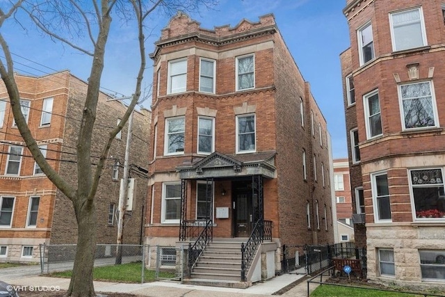 2151 W Cortez St, Chicago, IL 60622 - view of front facade with brick siding, a fenced front yard, and a gate