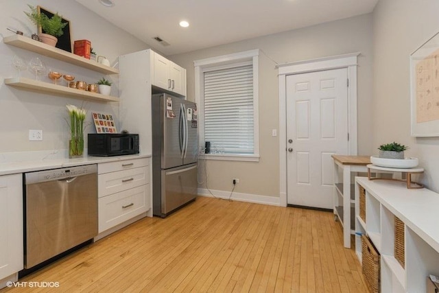 2151 W Cortez St, Chicago, IL 60622 - kitchen with stainless steel appliances, light countertops, white cabinetry, open shelves, and light wood-style flooring