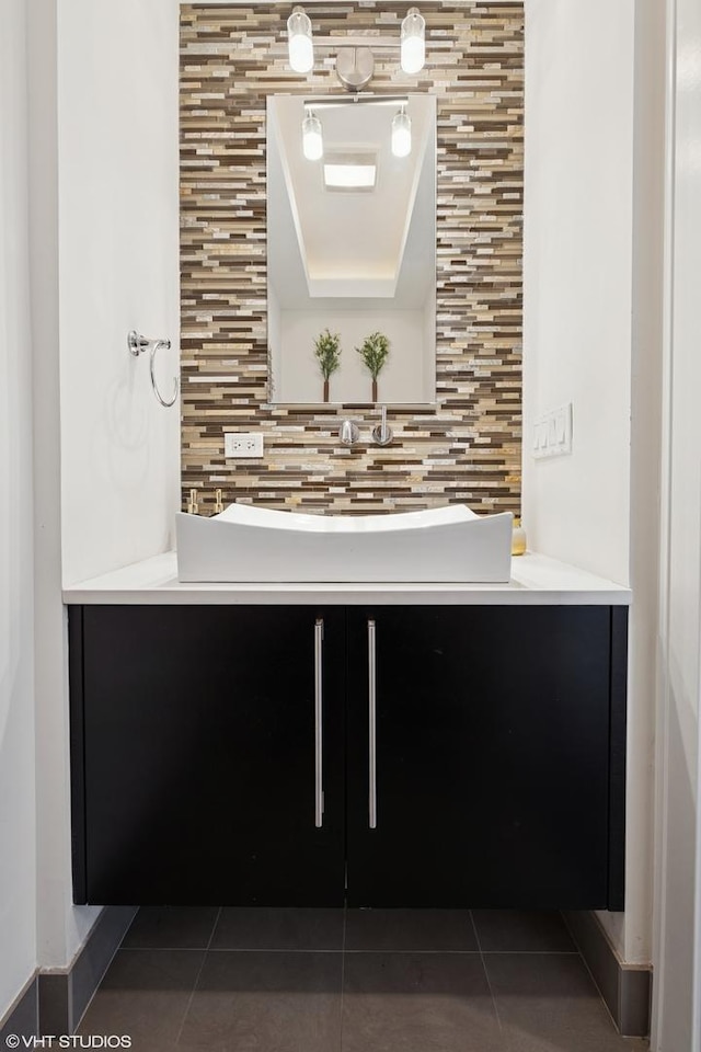 bathroom featuring decorative backsplash, tile patterned flooring, and a sink