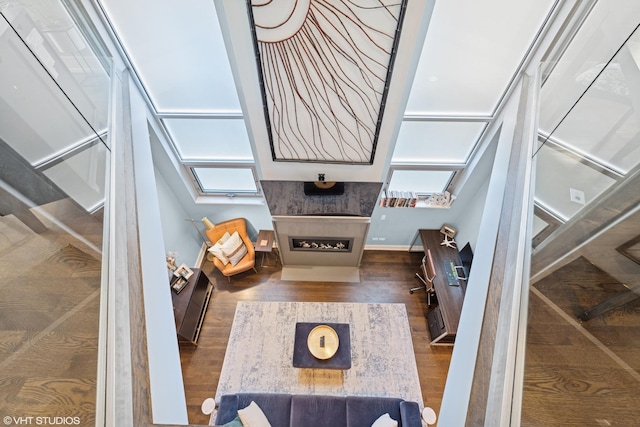 living area featuring wood finished floors, a fireplace, and baseboards