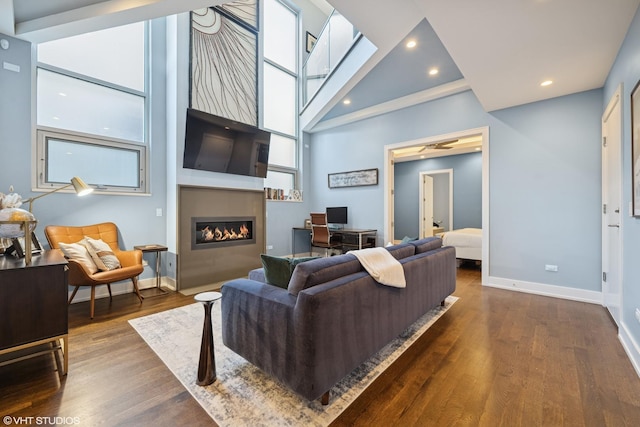living room with a large fireplace, dark wood-style flooring, baseboards, recessed lighting, and an office area