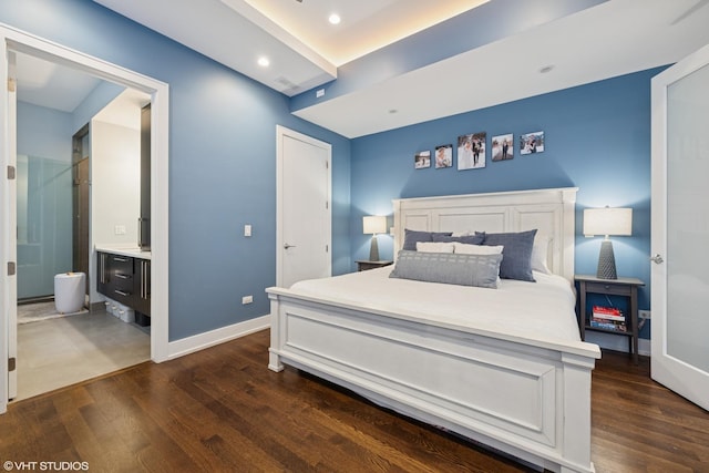 bedroom with dark wood-type flooring, baseboards, recessed lighting, and connected bathroom