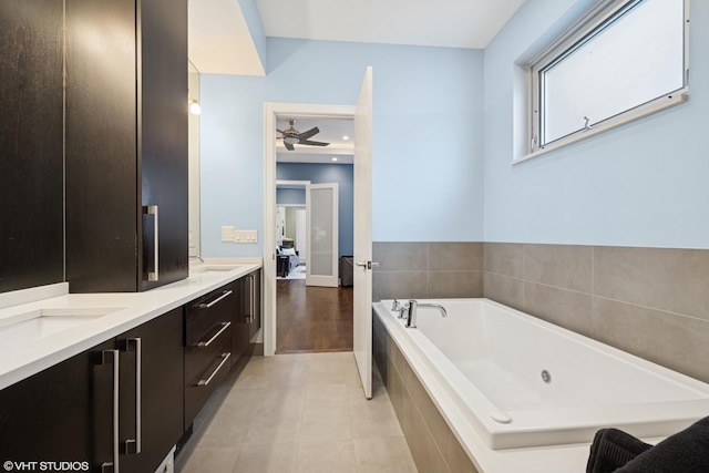 bathroom with a jetted tub, ceiling fan, double vanity, and tile patterned floors