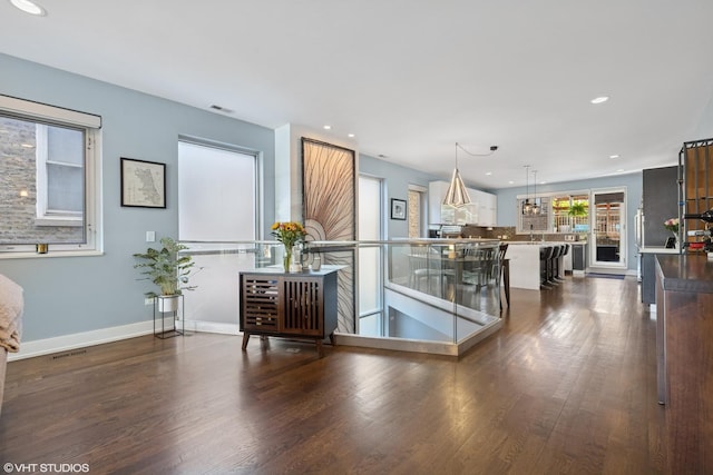 kitchen featuring dark wood finished floors, recessed lighting, decorative light fixtures, baseboards, and backsplash