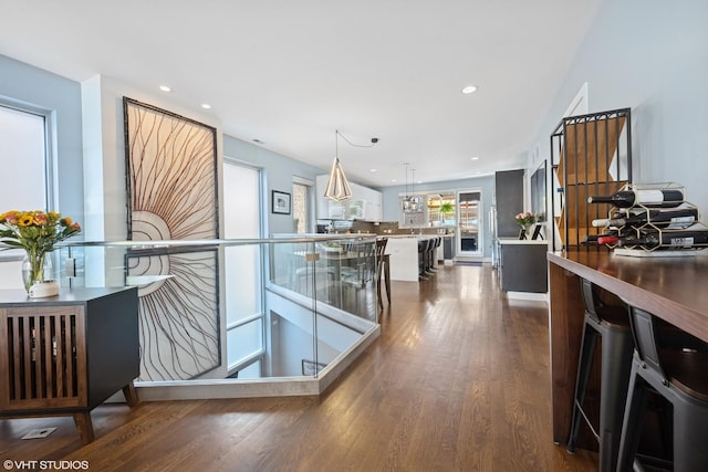 kitchen with dark wood-type flooring, recessed lighting, and hanging light fixtures