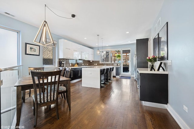 dining space featuring dark wood-style flooring, recessed lighting, and baseboards