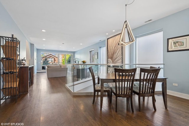 dining space with dark wood finished floors, baseboards, and recessed lighting