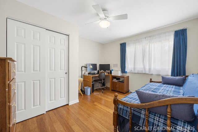 bedroom featuring wood finished floors, a desk, a closet, and ceiling fan