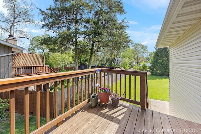 deck featuring a storage shed, an outbuilding, and a yard