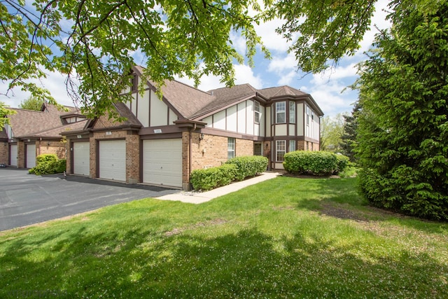 101 E Fabish Dr Unit 101, Buffalo Grove, IL 60089 - english style home featuring brick siding, a front lawn, roof with shingles, and asphalt driveway