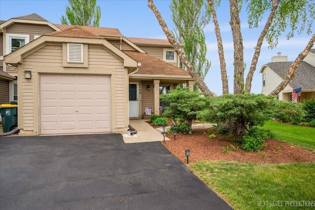 view of front of home with asphalt driveway, a shingled roof, and a garage