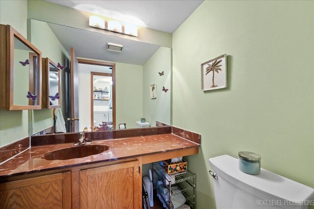 half bathroom with toilet and vanity