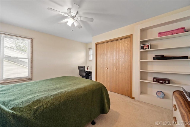 carpeted bedroom with a ceiling fan and a closet