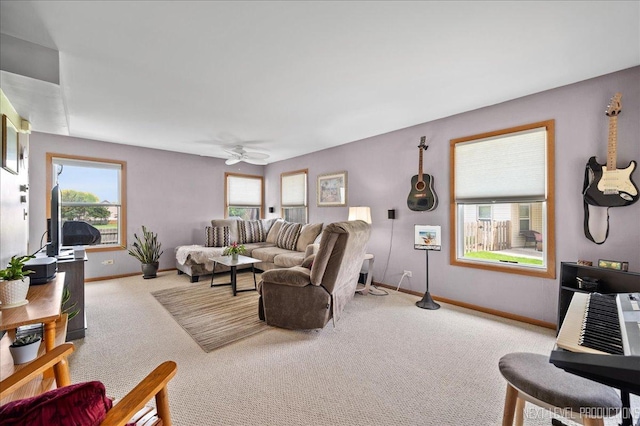 carpeted living area featuring baseboards, healthy amount of natural light, and ceiling fan