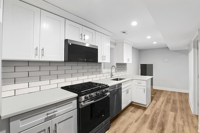 3839 W 14th St, Chicago, IL 60623 - kitchen with appliances with stainless steel finishes, backsplash, white cabinetry, light countertops, and light wood-type flooring