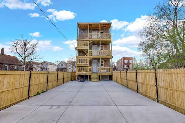 1315 S Kolin Ave, Chicago, IL 60623 - back of property featuring a balcony, a fenced backyard, stairway, and brick siding