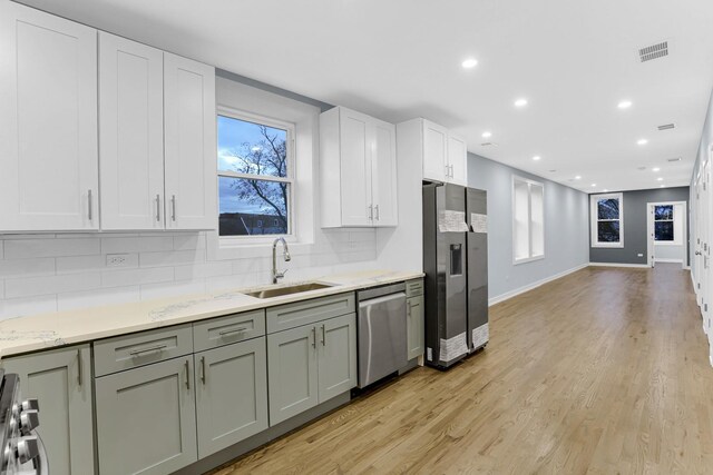 1315 S Kolin Ave, Chicago, IL 60623 - kitchen featuring stainless steel appliances, a sink, tasteful backsplash, light wood finished floors, and recessed lighting