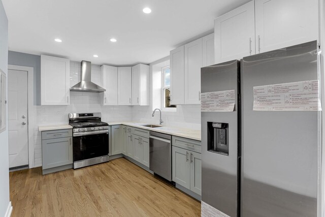 1315 S Kolin Ave, Chicago, IL 60623 - kitchen with wall chimney exhaust hood, appliances with stainless steel finishes, gray cabinets, a sink, and light countertops