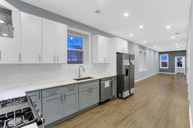 1315 S Kolin Ave, Chicago, IL 60623 - kitchen featuring stainless steel appliances, a sink, recessed lighting, light wood-style floors, and light stone countertops