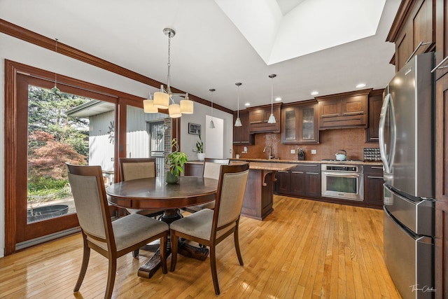 15322 Woodmar Dr, Orland Park, IL 60462 - kitchen featuring stainless steel appliances, light wood finished floors, a sink, tasteful backsplash, and dark brown cabinetry